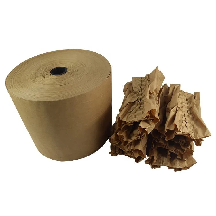 Roll of brown kraft packing paper beside crumpled brown paper void fill on a white background