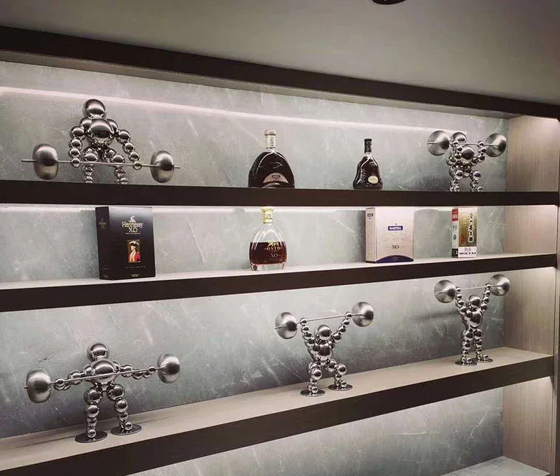 Shelves displaying silver weightlifting figures and assorted liquor bottles.