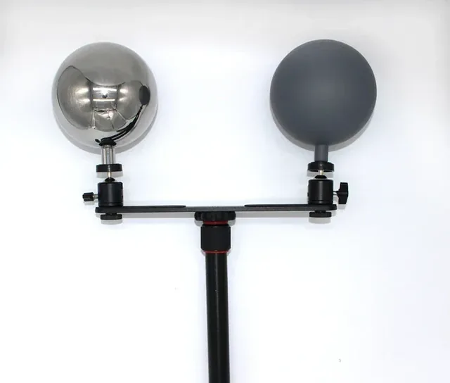 Chrome and matte gray spheres mounted side by side on a black pole with adjustable clamps, white background