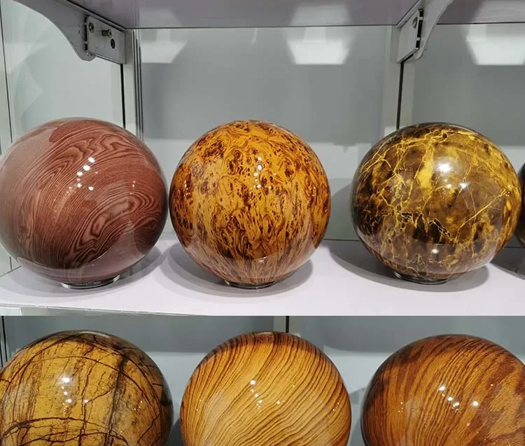 Polished patterned stone spheres in several colors displayed on shelves of a glass showroom case