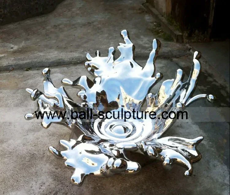 Polished stainless steel water splash sculpture displayed on outdoor concrete pavement