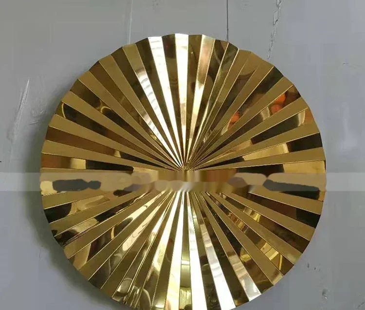 Gold circular metal sunburst wall art with radiating slats.