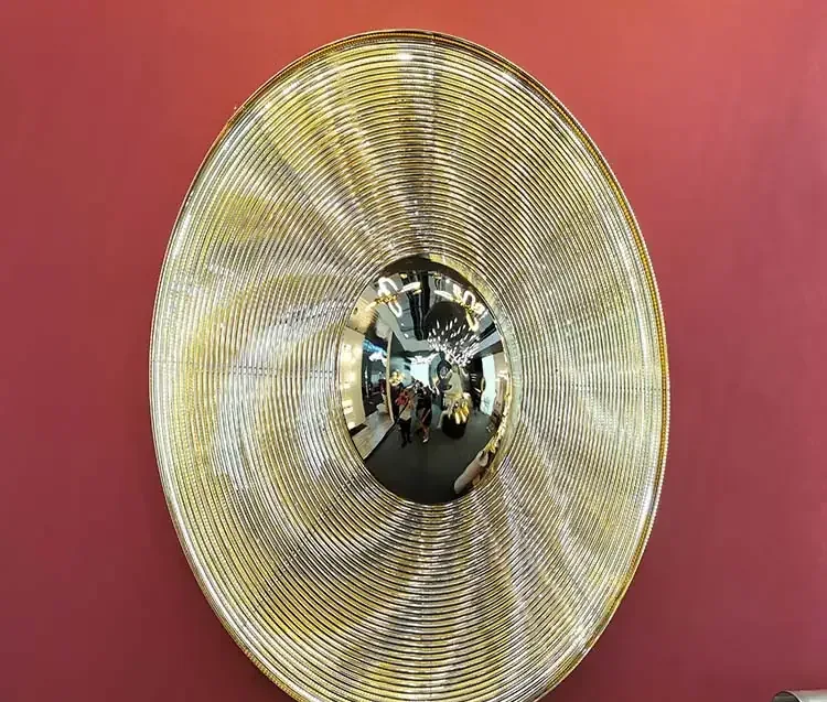 A large golden cymbal with concentric grooves and a polished bell mounted against a red background.