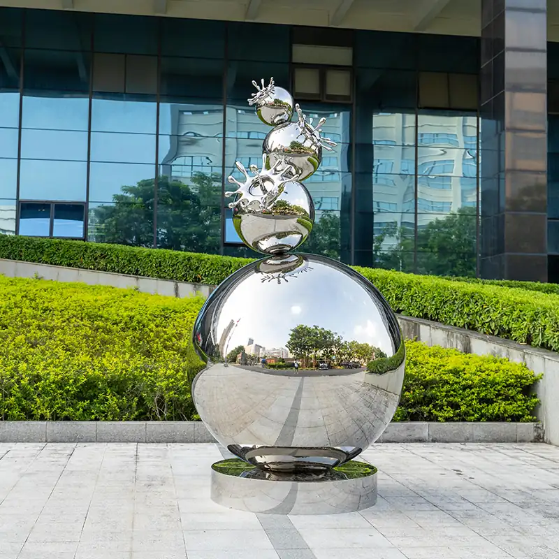 Stacked polished stainless steel spheres forming an outdoor sculpture