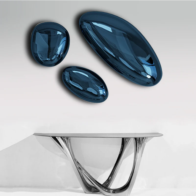 Blue mirror finished stone shaped wall discs above a console table