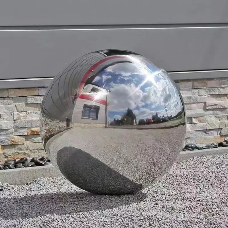 Large mirror polished stainless steel garden sphere reflecting the sky