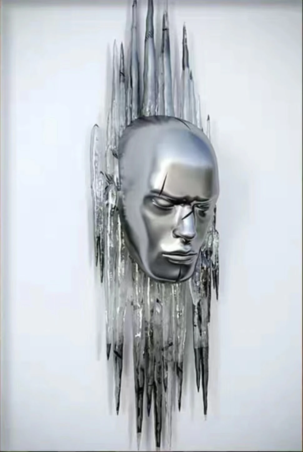 Chrome finished sculpted face emerging from a metal form