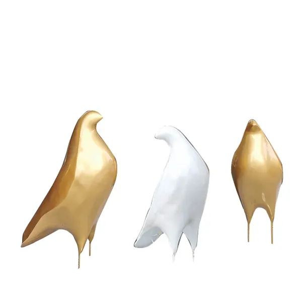 Three glossy abstract bird figurines, two gold and one white, displayed on a plain white background