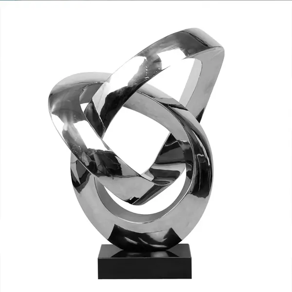 Polished stainless steel abstract sculpture with interlocking rings on a black base