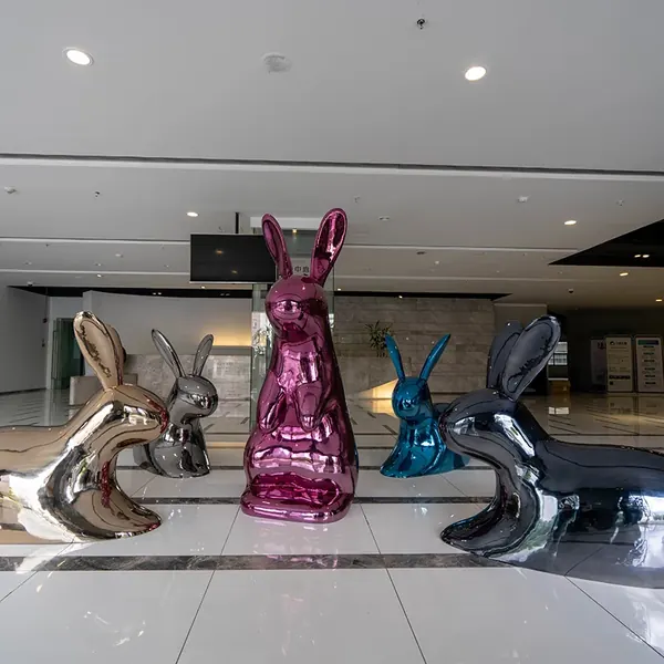 Group of mirror polished rabbit sculptures in a hotel lobby