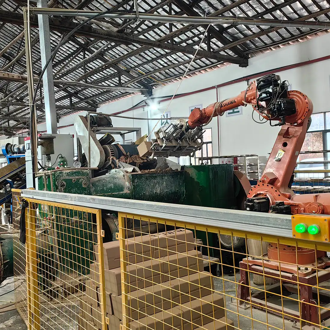 Robotic arm feeding the clay extrusion line inside the Baolifeng insulator plant