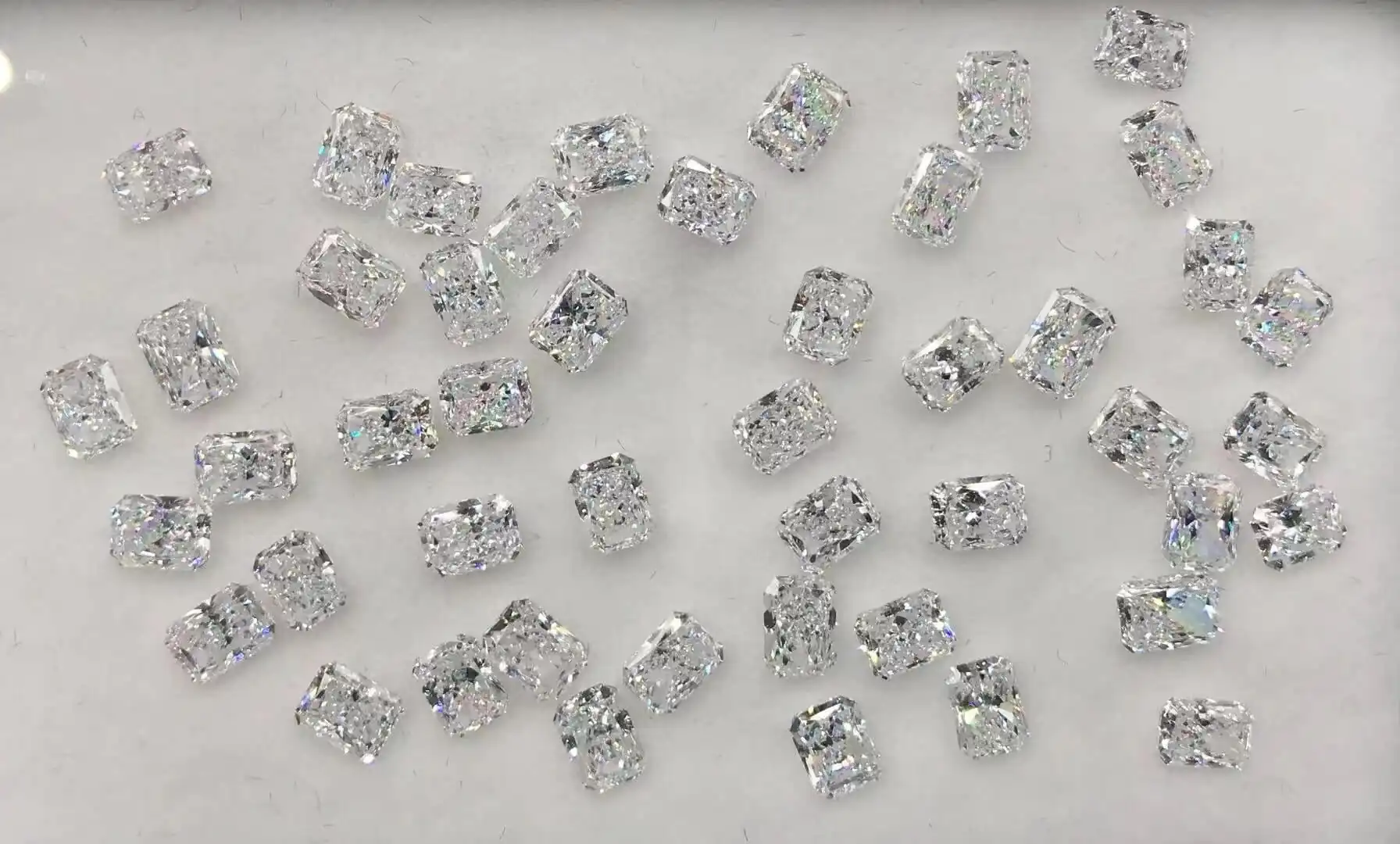 A full eternity band of matched radiant cut white diamonds photographed on a black ground
