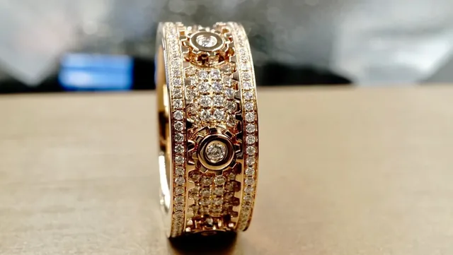 An ornate geometric rose gold spinner band ring photographed at BH Jewelry