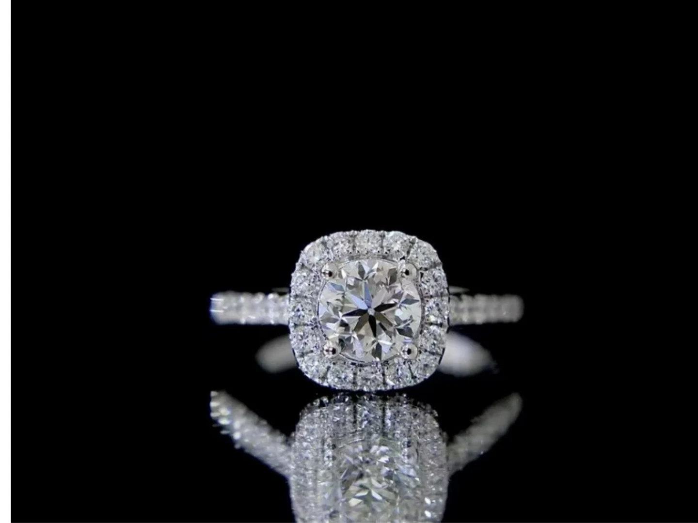 A vintage-style diamond engagement ring held in a gloved hand at BH Jewelry