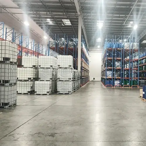Warehouse aisle stacked with 200kg silicone fluid drums ready for export