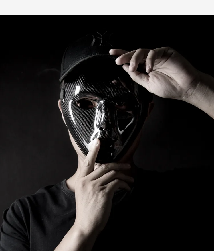 Forged carbon fiber shell part held up against a dark background