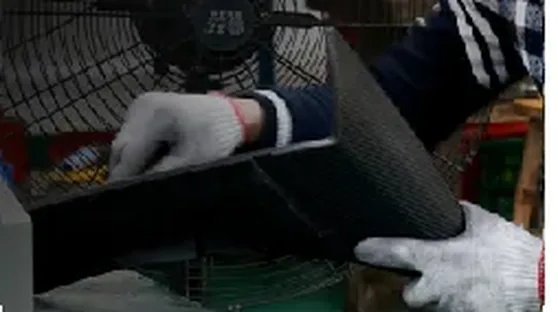Operator in gloves handling a cured carbon fiber panel