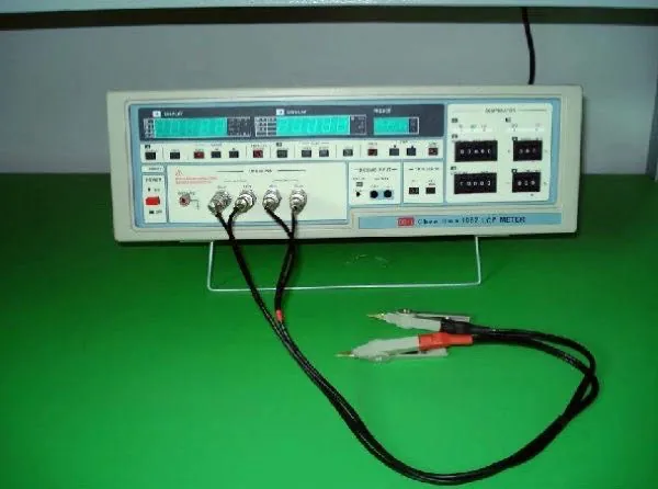 Electrical test bench. LCR meter with Kelvin clips for inductance and resistance checks.