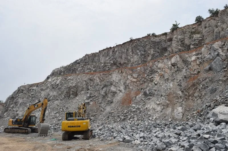 Excavators working the open-pit quarry face