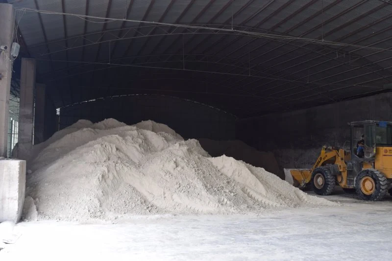 Wheel loader beside a powder stockpile in the storage building