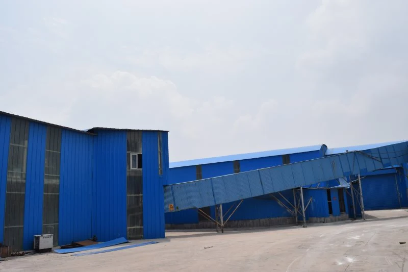 Blue-clad processing building and material conveyor