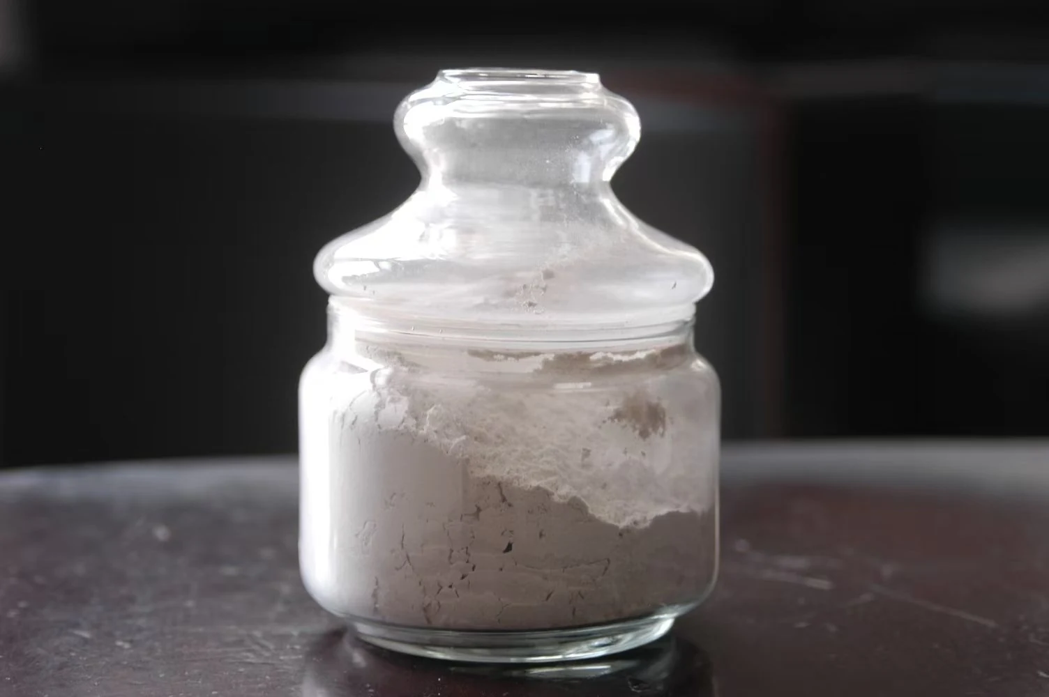 Nepheline powder sample in a glass sample jar