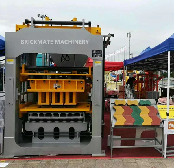 Cement block making machine on display with sample blocks