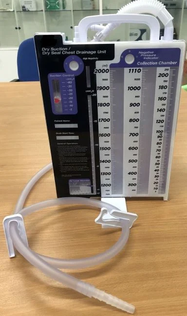 Dry suction dry seal chest drainage unit with tubing on a wooden table
