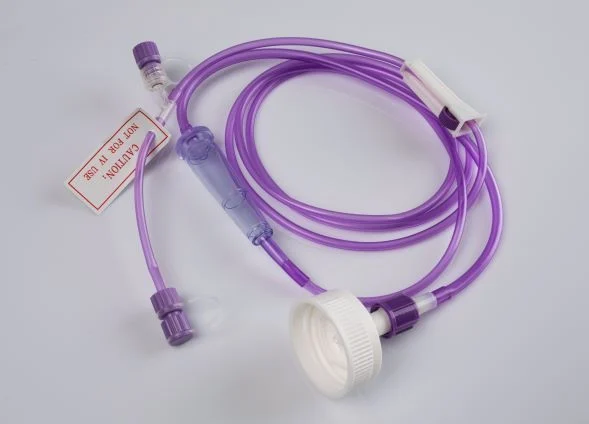Purple medical tubing set with drip chamber, roller clamp, connectors, and caution tag on plain background