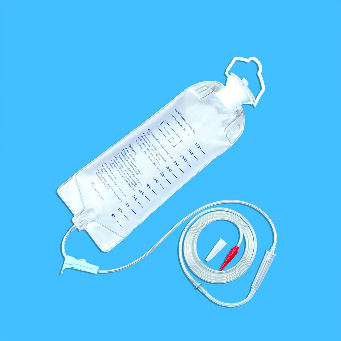 Medical enteral feeding bag with coiled tubing and connector on a blue background