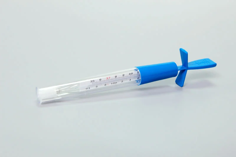 Glass thermometer inside a blue plastic case on a neutral background