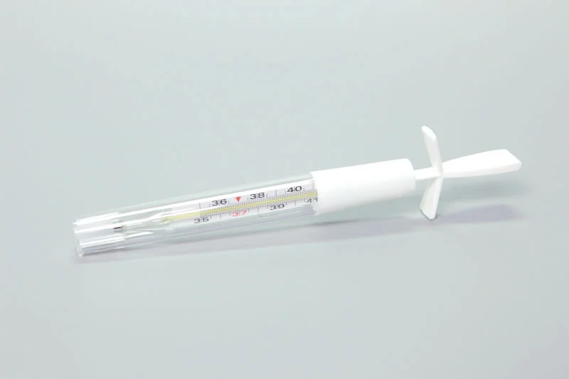 Clinical glass thermometer inside a transparent plastic case with white cap