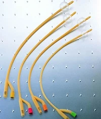 Four latex Foley catheters with inflated balloons arranged on a perforated metal surface