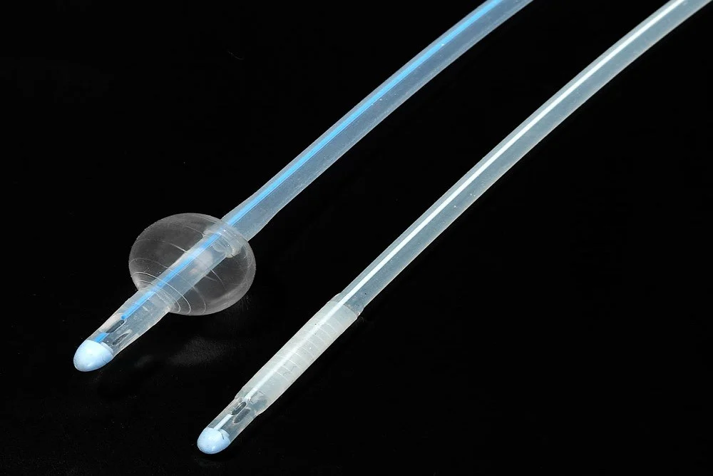 Close-up of silicone Foley catheter tips with inflated and deflated balloons on black background