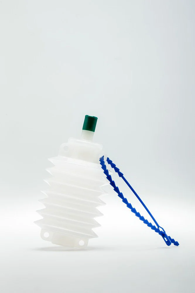 White plastic bellows bottle with green cap and blue strap on a white background