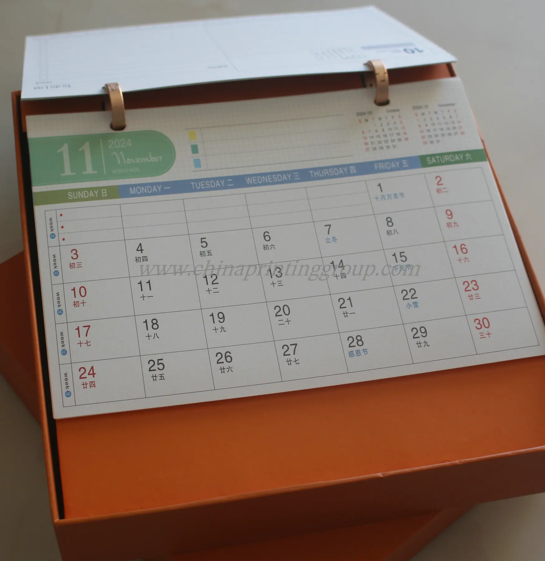 Spiral bound desk calendar standing open on a table