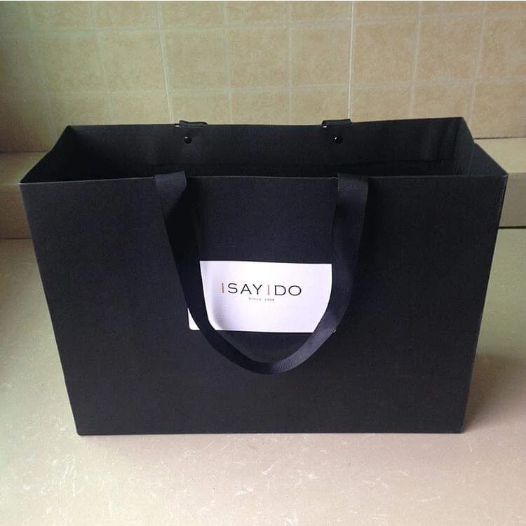 Custom printed paper shopping bag shown from the front with ribbon handles