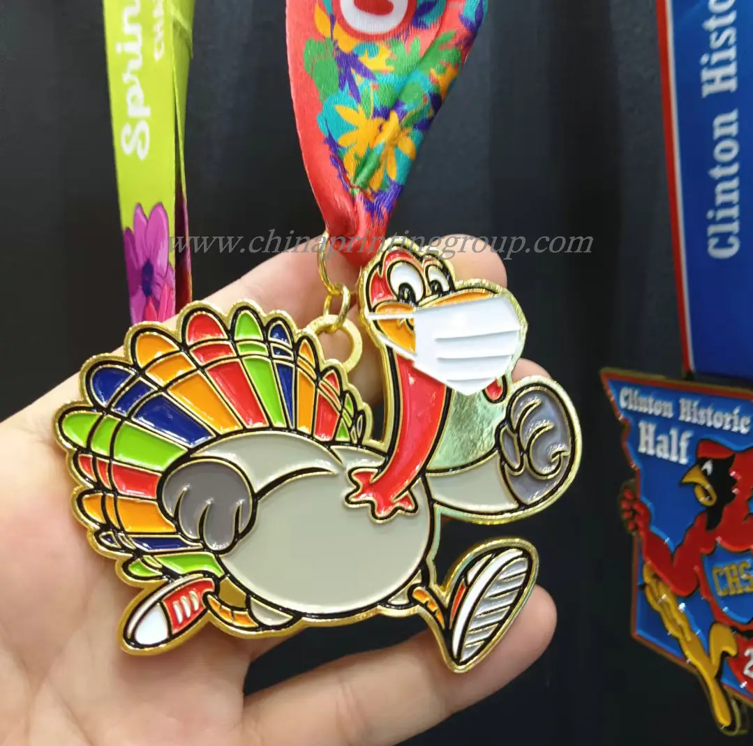 Assorted enamel pins and metal keychains in gold plating