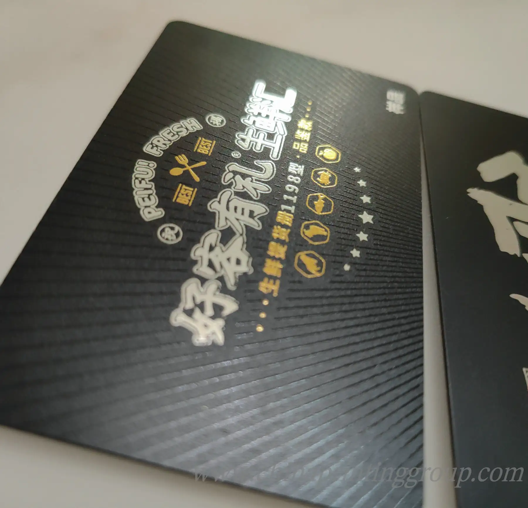 Transparent PVC business card with printed logo held against a light background