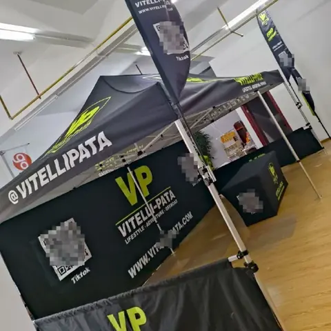 Custom printed pop up canopy tent with branded back wall at an outdoor expo