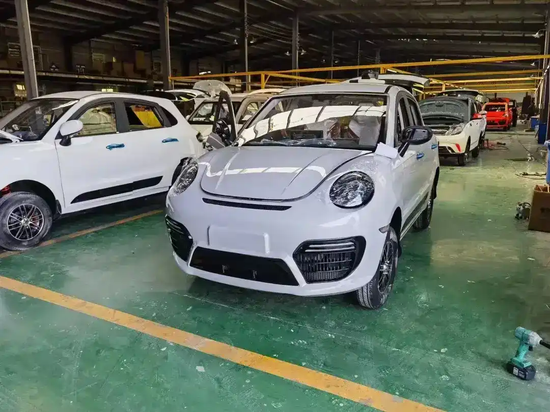 White 4-seat mini electric car parked on a concrete lot, front three-quarter view