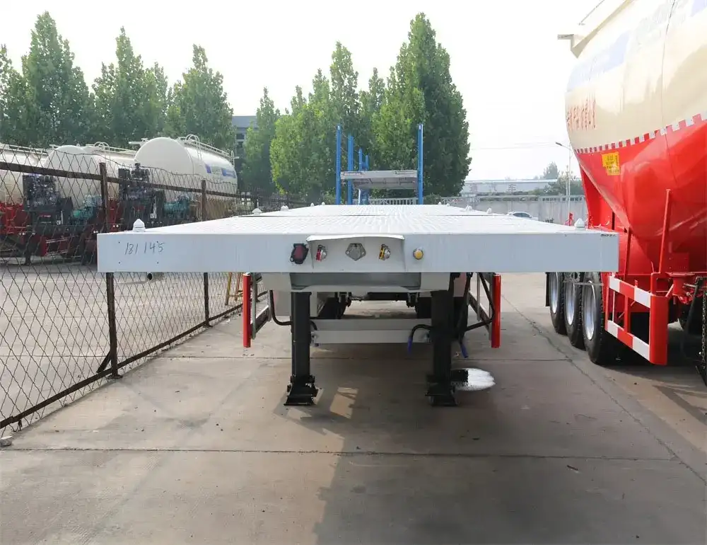 3-axle flatbed side wall semi-trailer in green, front three-quarter view with king pin and landing gear visible