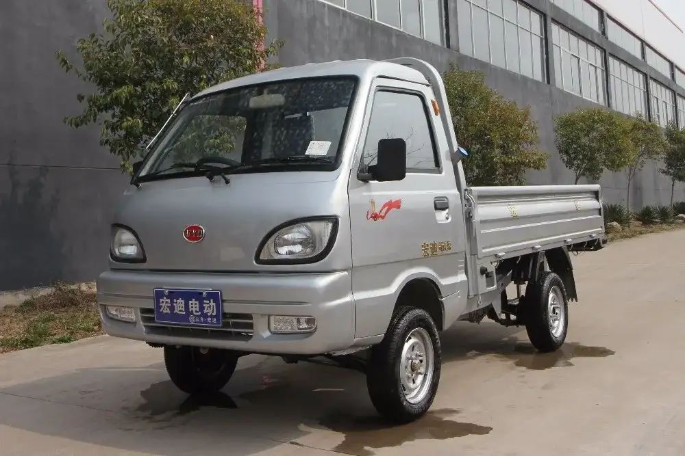 Front three-quarter view of a white 4 kW electric mini truck with left-hand steering and headlight