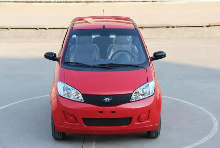 White 3-seater mini electric car with two doors and aluminum wheels parked on a concrete lot