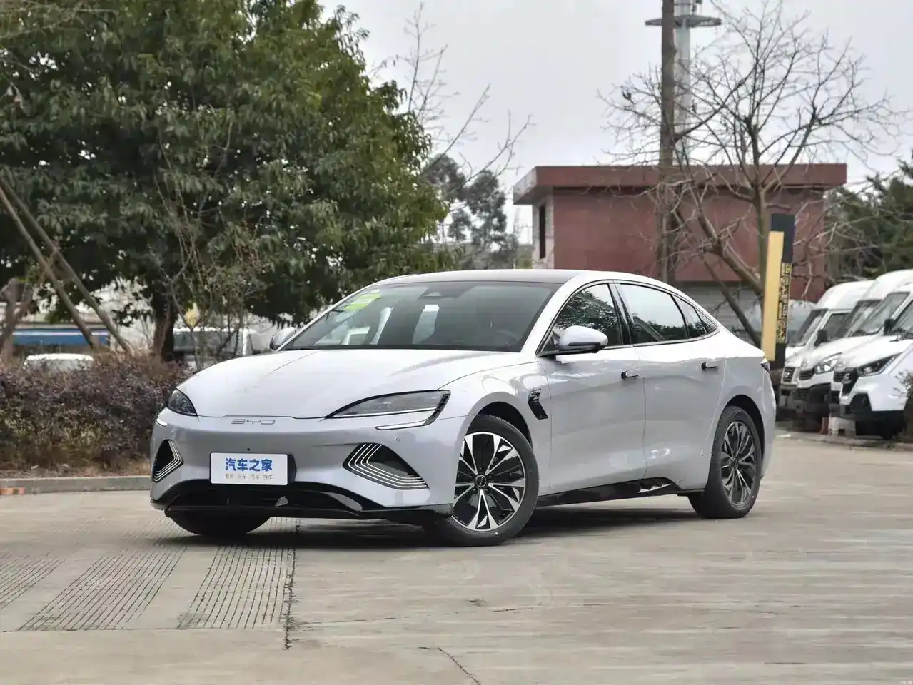 Front three-quarter view of a white BYD Tang EV electric SUV with 7 seats, showing LED headlights and front grille