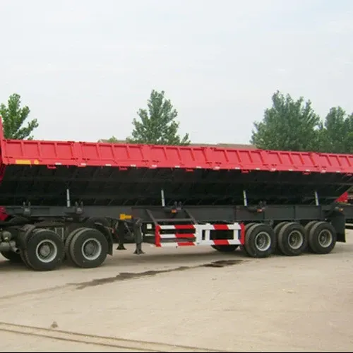 White 3-axle dump semi trailer parked on a yard, front three-quarter view