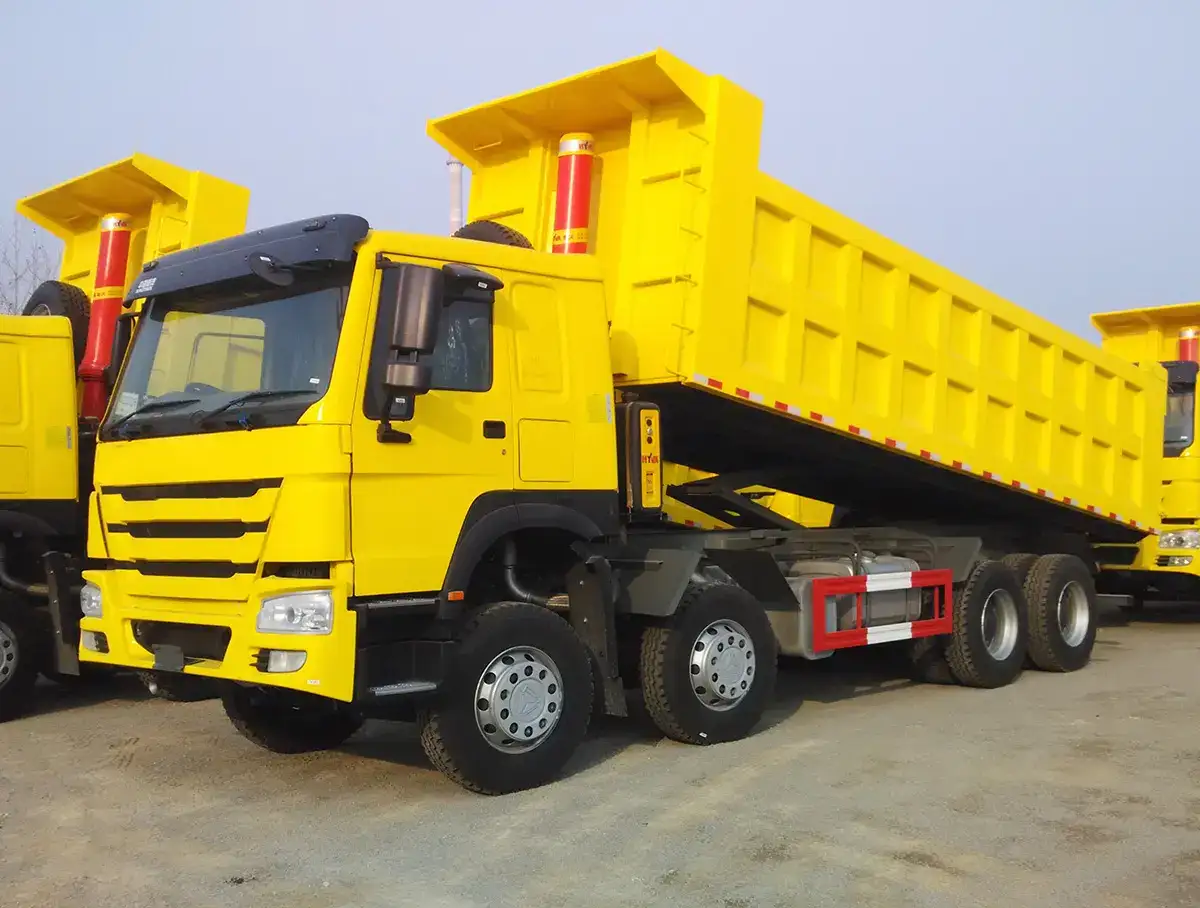 White HOWO A7 8x4 dump truck parked on a yard, front three-quarter view