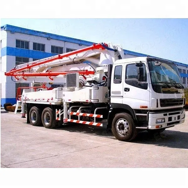 White concrete pump truck with 56m boom extended, parked on a construction yard
