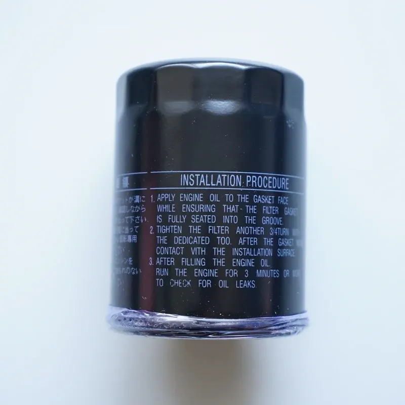 Black oil filter 90915-YZZD4 with iron housing, mounted on a Toyota engine, side view