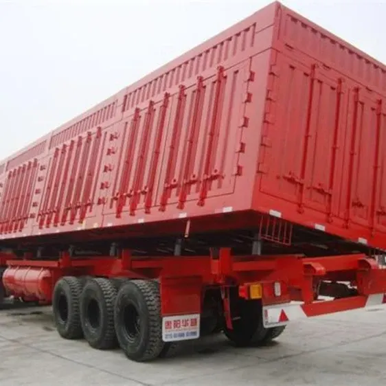 Side dump semi trailer in white, parked on a yard with side gate open